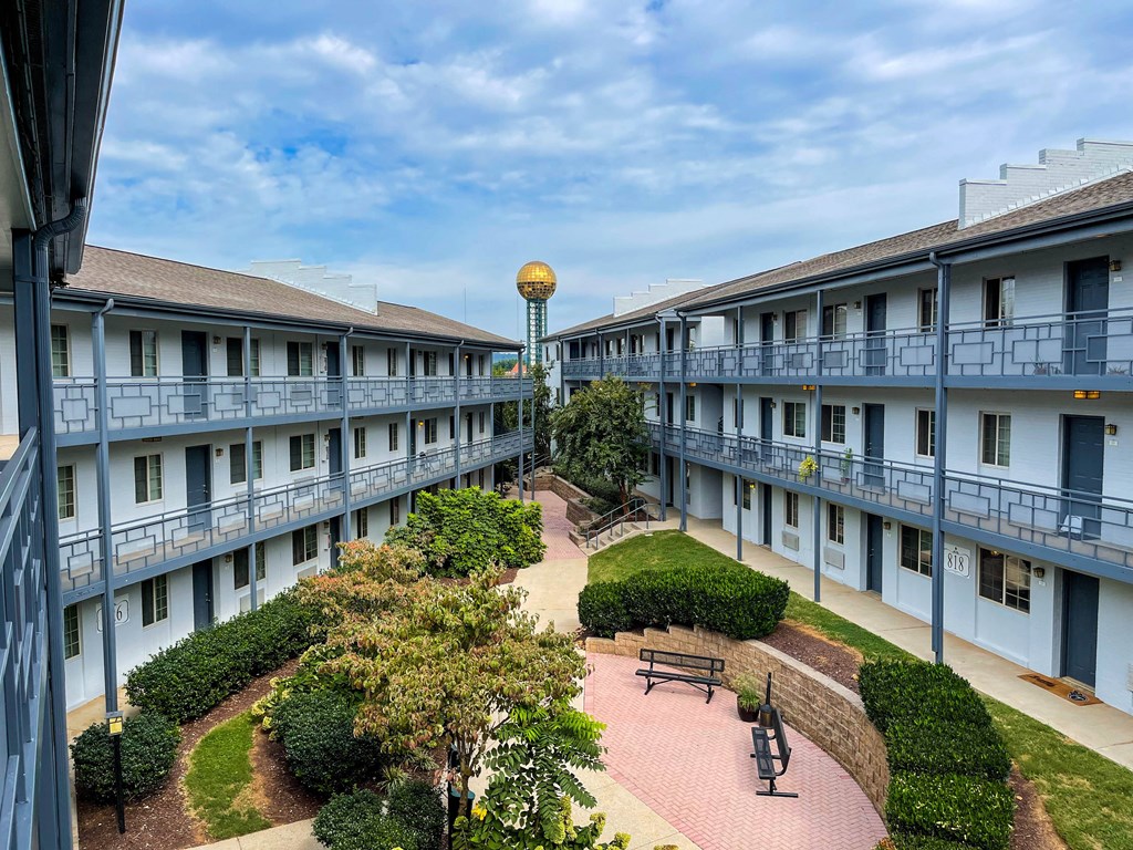 a courtyard in the middle of a building with trees and benches