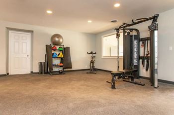A spacious home gym with a variety of exercise equipment.