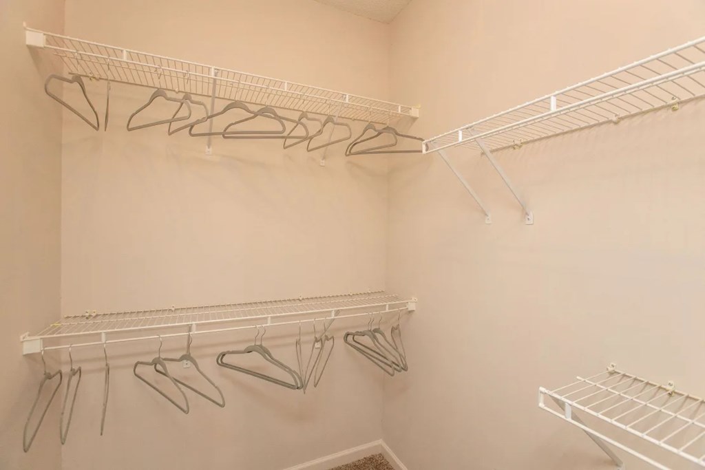 Empty white shelves with clothes hangers.
