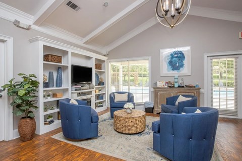 A living room with blue chairs and a wooden floor.
