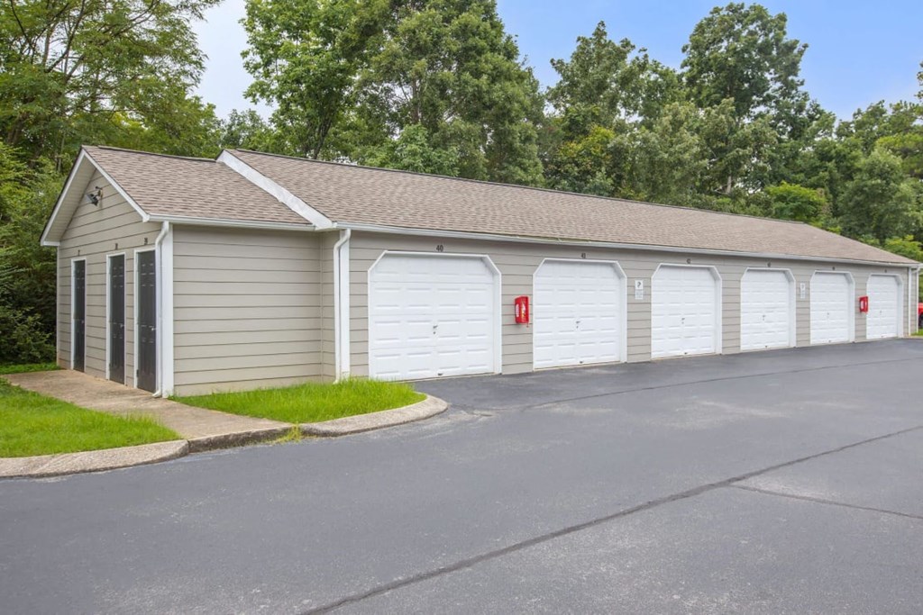 A building with a grey roof and white garage doors.