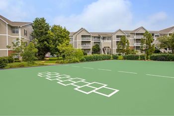 A tennis court in front of apartment buildings.
