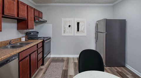 A kitchen with brown cabinets and a black chair.