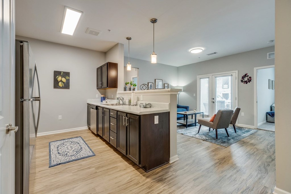 a kitchen and living room with a refrigerator and a sink