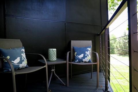 two chairs and a table on a balcony