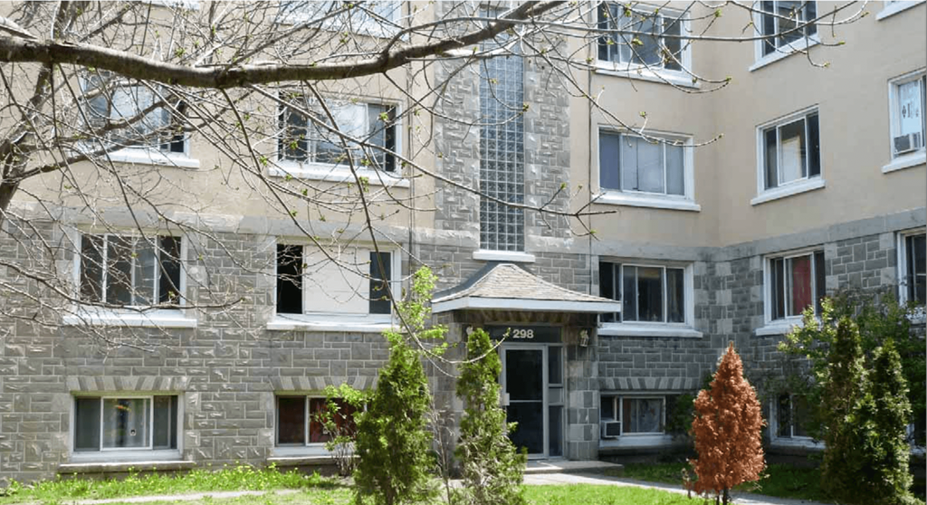 an apartment building with trees in front of it