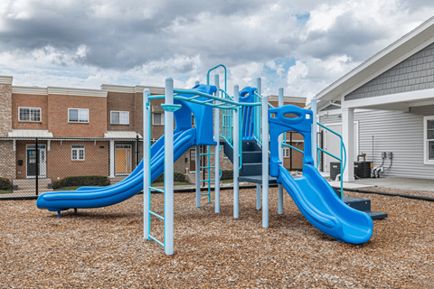 A blue and white playground slide in a residential area.