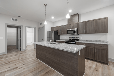 A modern kitchen with a granite countertop and wooden cabinets.