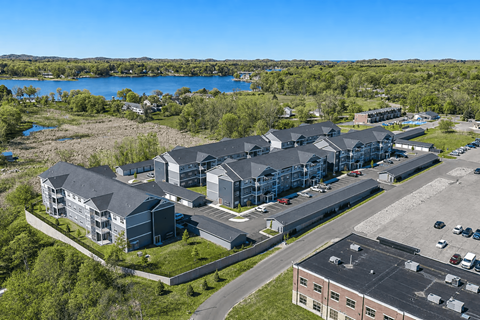 A large building complex with a parking lot in front.