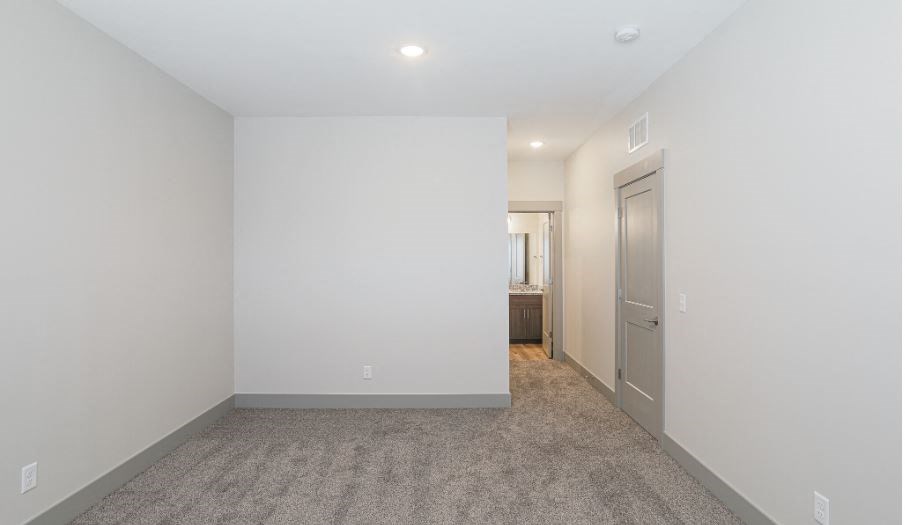 a room with a white wall and a door to a bathroom
