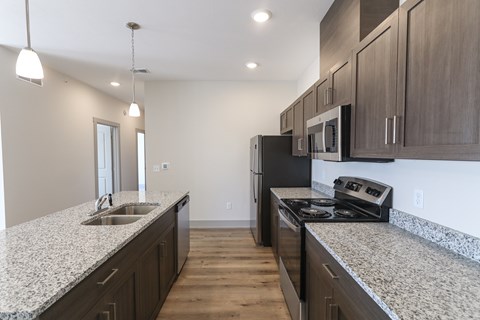 A kitchen with granite countertops and stainless steel appliances.