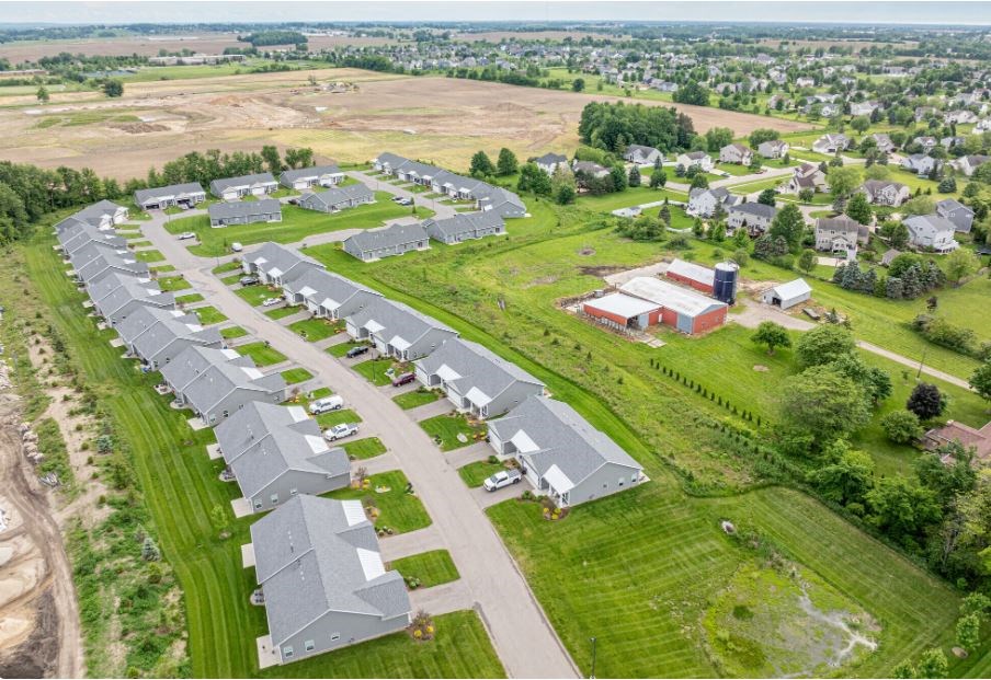 an aerial view of a neighborhood of houses in a field