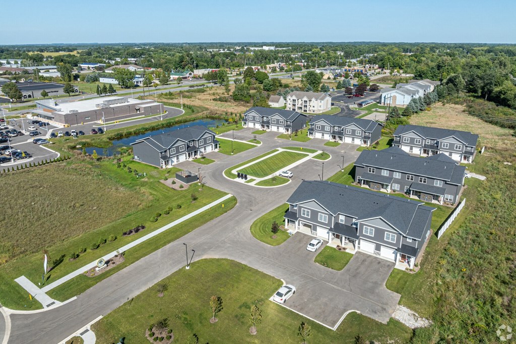 A bird's eye view of a residential area with houses and a parking lot.