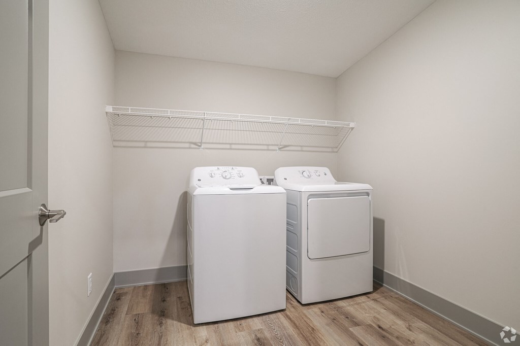 Two white front loading washing machines in a laundry room.