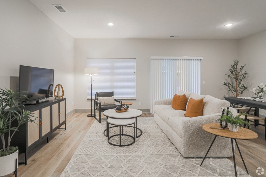 A living room with a white couch, a television, and a coffee table.