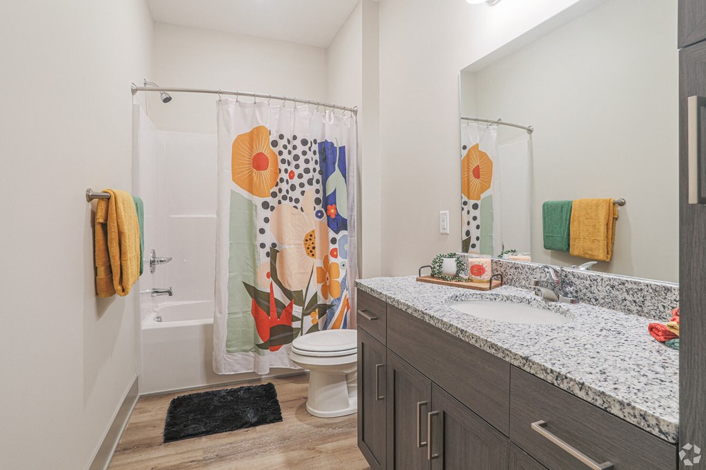 A bathroom with a toilet, sink, and shower curtain.