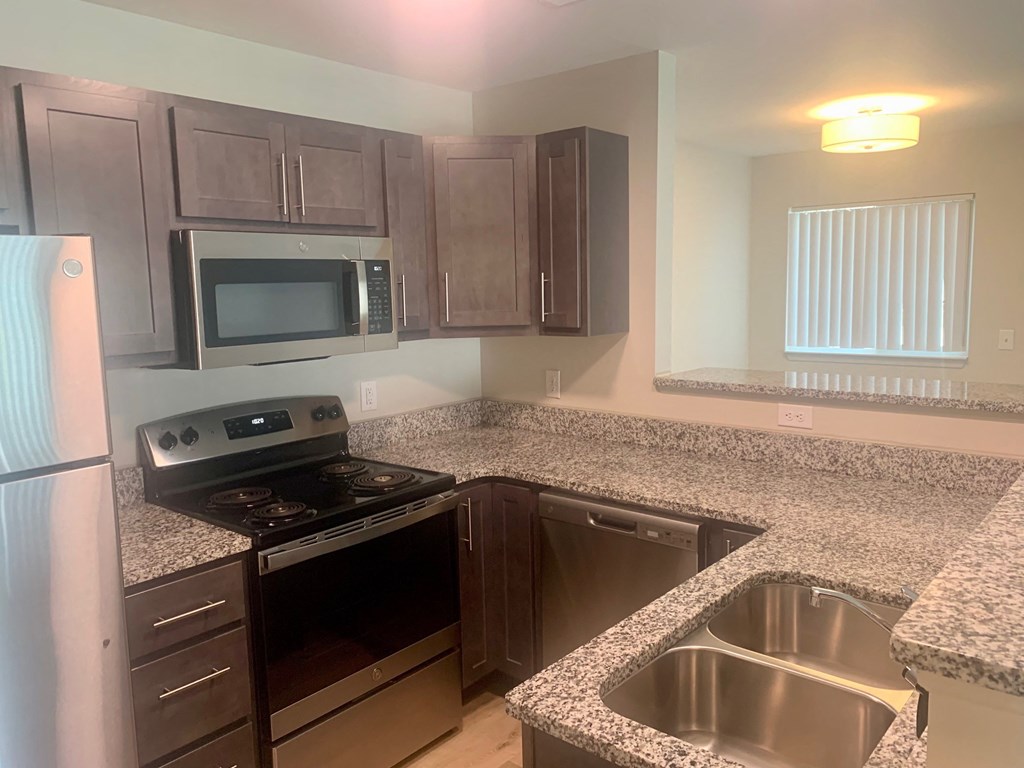 a kitchen with granite countertops and stainless steel appliances
