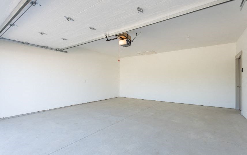 an empty room with a white wall and a door