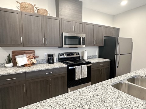 A kitchen with a black stove top oven and a black refrigerator.