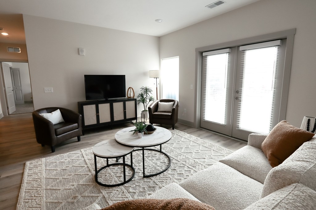 A living room with a white couch and a black television.