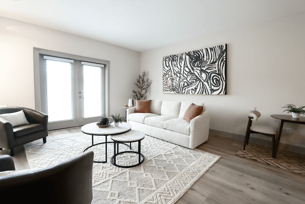 A living room with a white couch, a coffee table, and a large abstract painting on the wall.