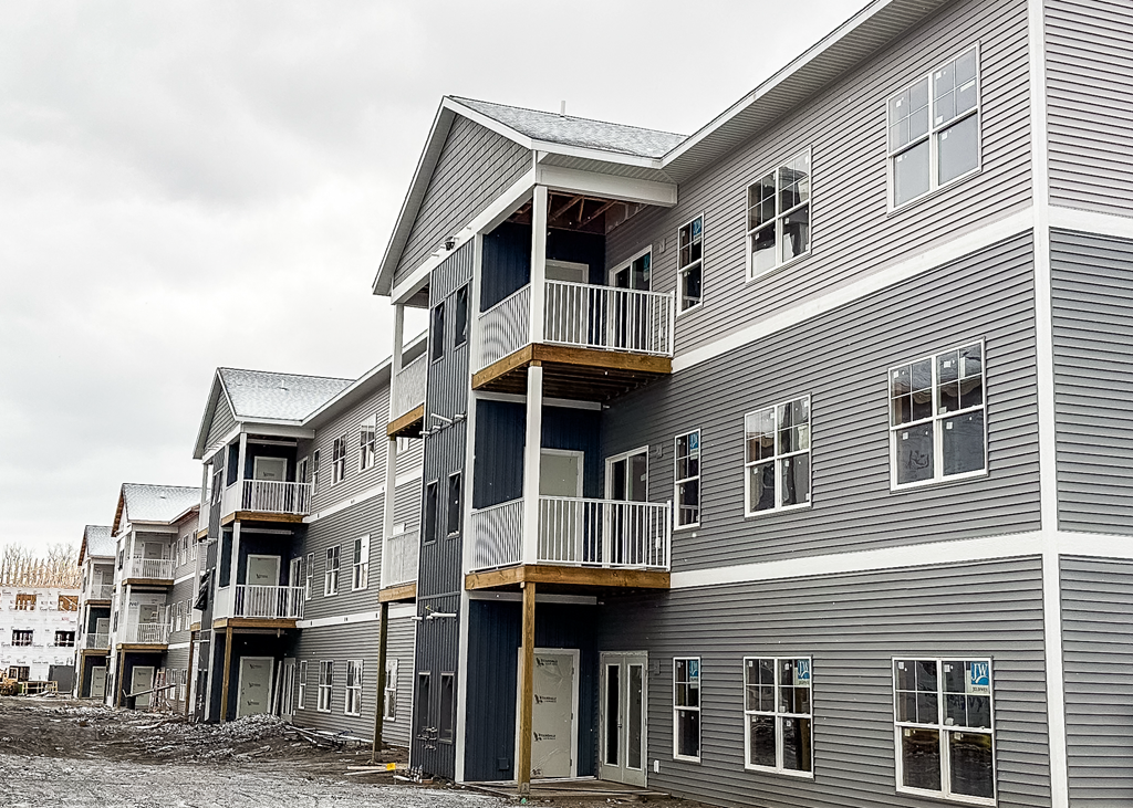 A grey building with a balcony on the second floor.