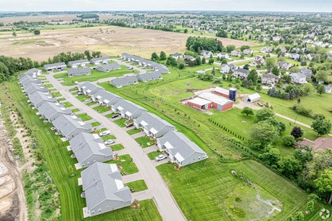 A large, modern building is surrounded by a long row of houses.