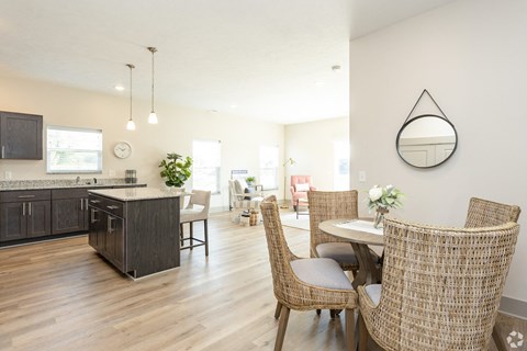 A modern kitchen with a dining table set for two.