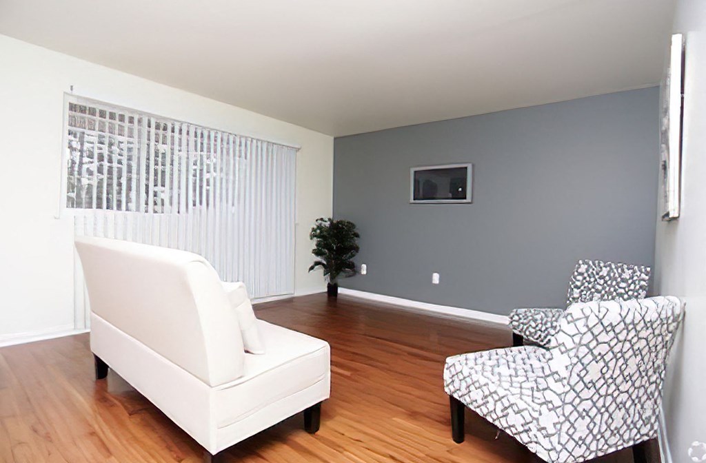 a living room with a white couch and two chairs