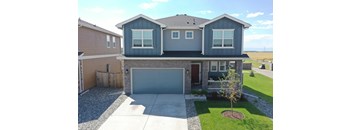 the front of a blue house with a garage door