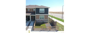 the front of a house with a yard and a fence