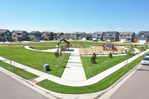 a park with a playground and houses in the background