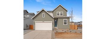 A two-story house with a garage and a driveway.