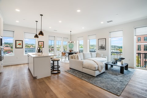 a living room with a couch and a kitchen with a counter top