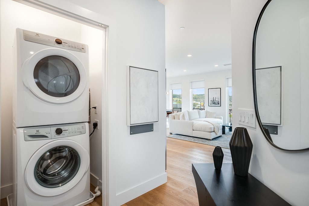a front loading washer and dryer in a living room next to a door