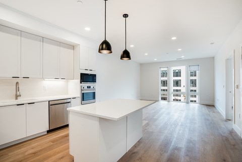 a large white kitchen with a white island and white cabinets