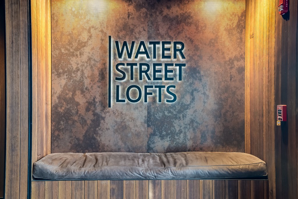 a water street lotus bench in front of a wall with water street lofts
