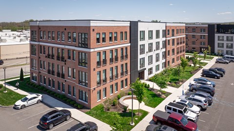 A parking lot with cars and a building with red brick walls.