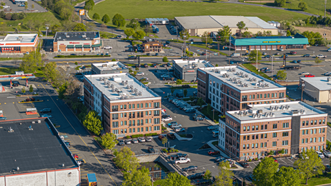 A large parking lot is surrounded by several buildings.