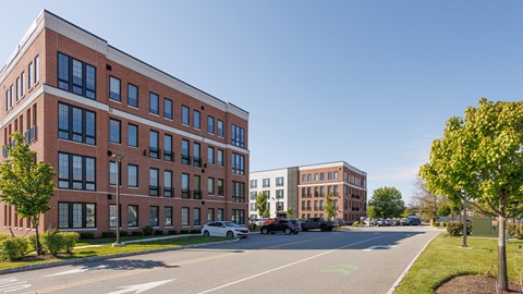 A red brick building with a white car parked in front.