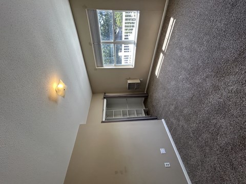 A small window with a view of trees is on the wall.