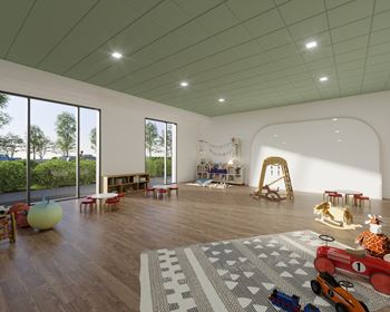 A room with a green ceiling and wooden floors, furnished with a sofa, chairs, and a play area for children.