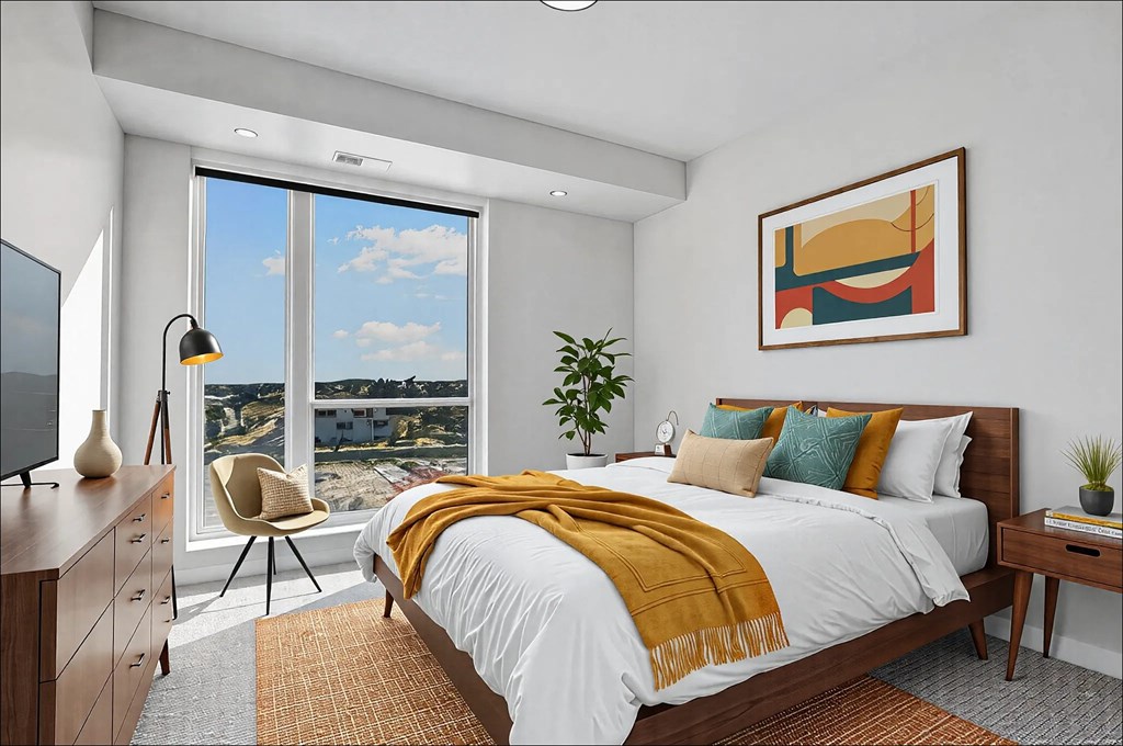 A bedroom with a large bed and a view of the city.