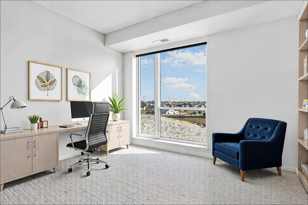 A room with a desk, chair, and a view of the outside through a large window.