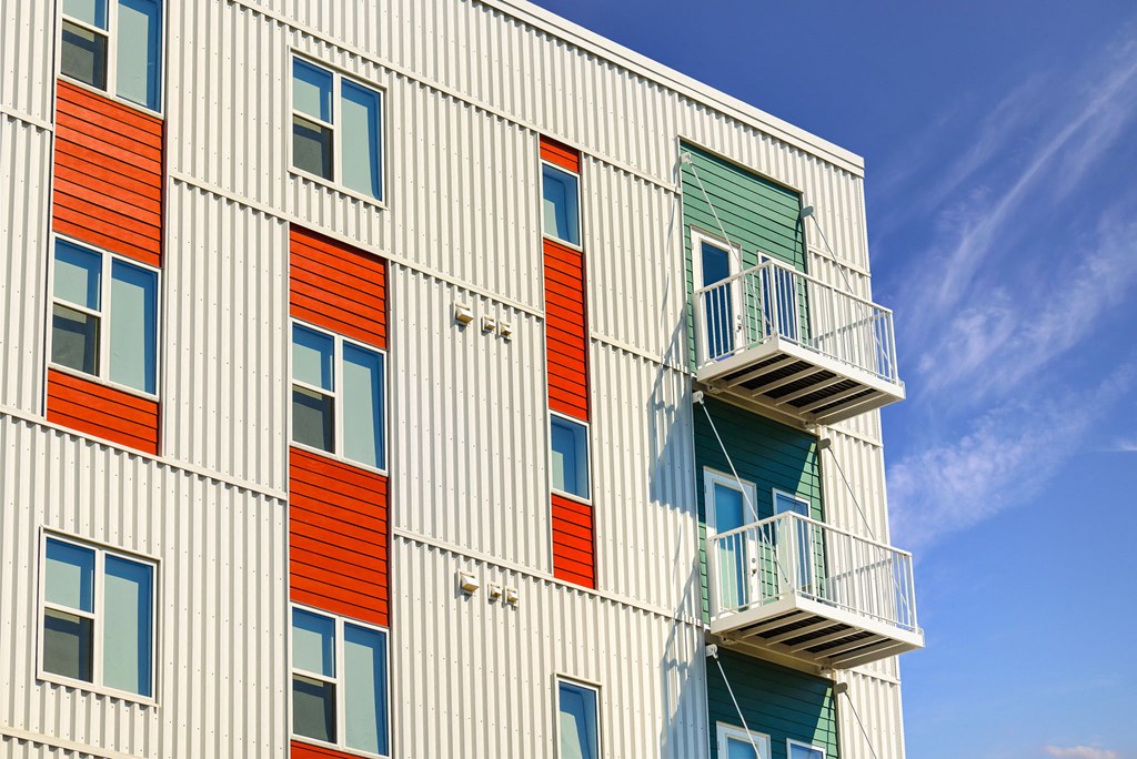 a building with colorful doors and balconies and a blue sky