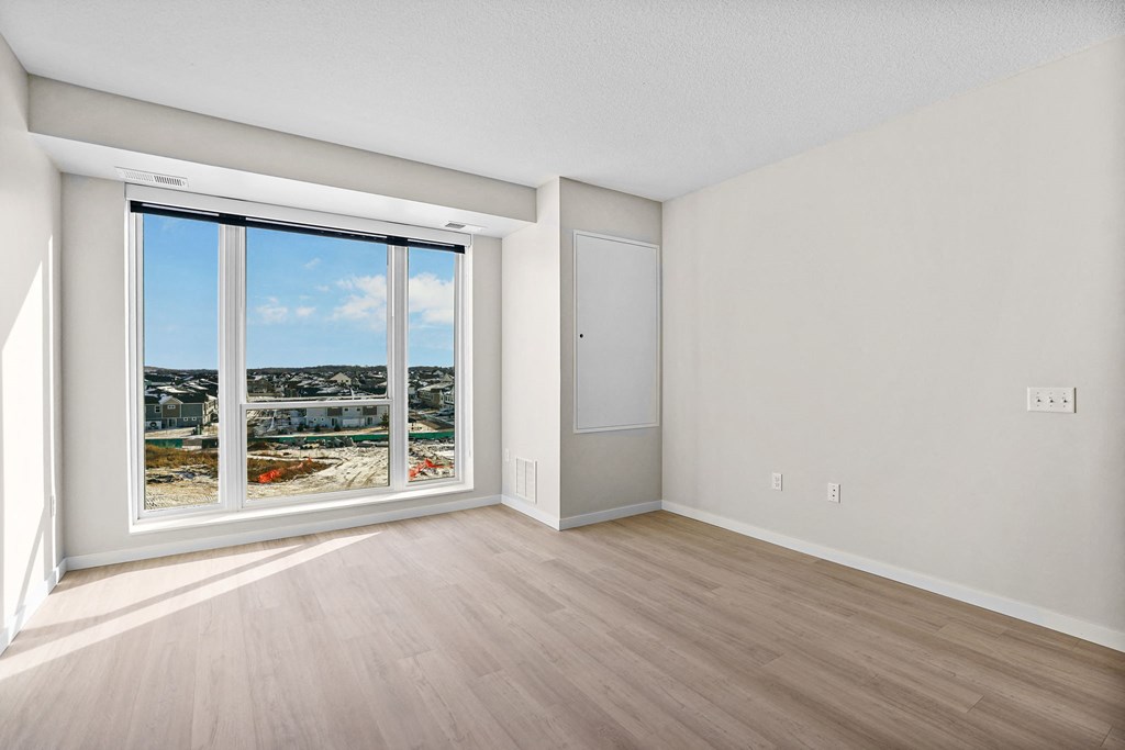 A room with a large window and a closed door.