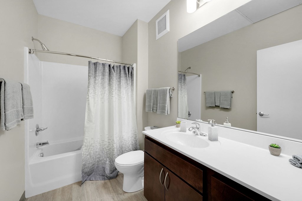 a bathroom with a white sink and toilet next to a white bathtub with a shower curtain