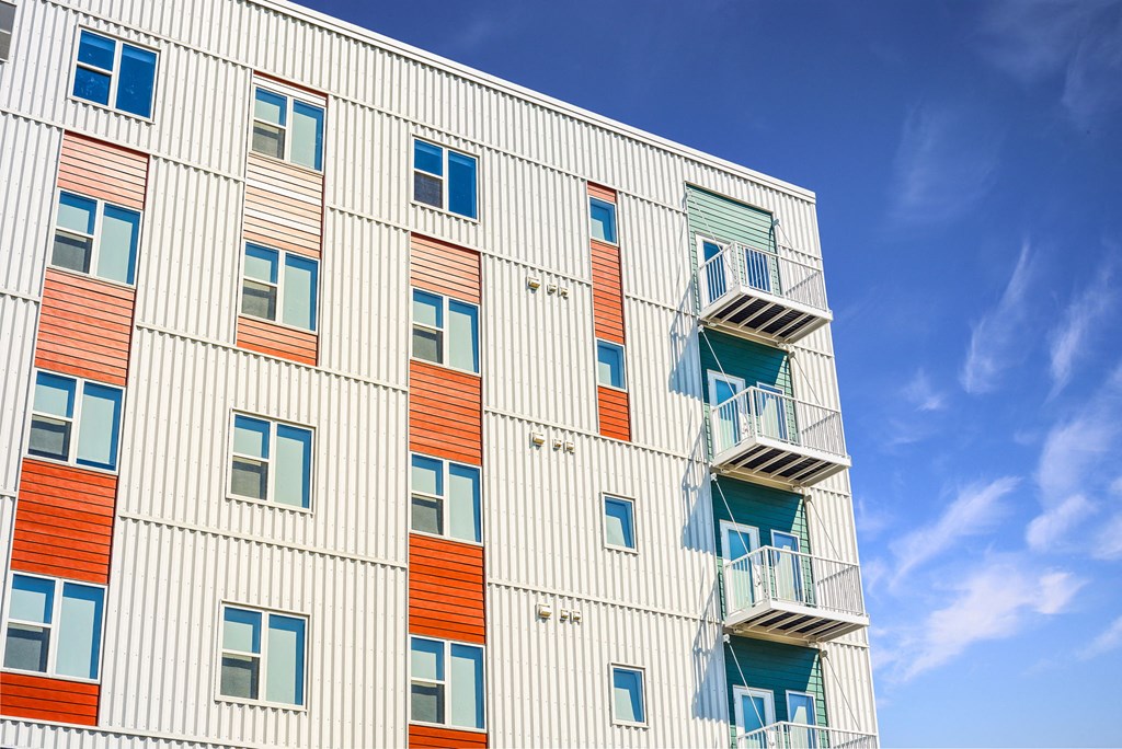a tall building with balconies and a blue sky