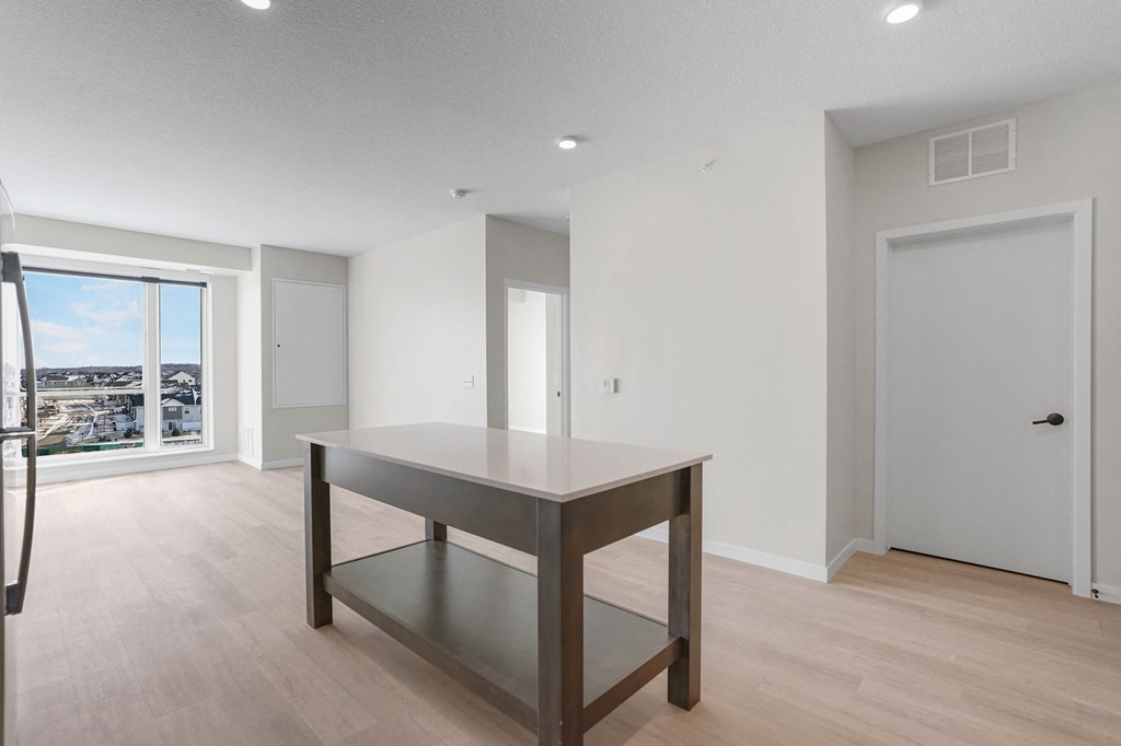 A modern kitchen with a table and a view of the mountains.