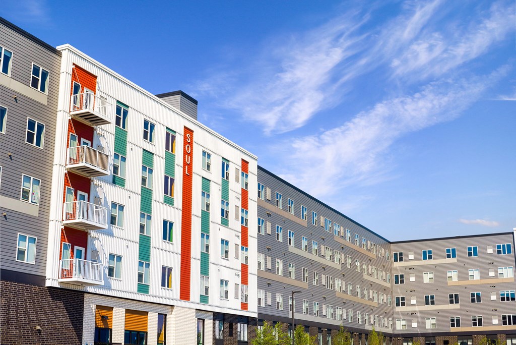 a large apartment building with a blue sky in the background